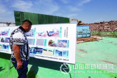 工作人员在建筑垃圾资源化流程图前驻足观看