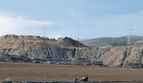 远处围墙内,洗煤厂已被关停。不远处未受污染的旱田已开始准备春播