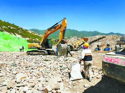燕山凤凰亭2号涵洞黑渣土场上,工人正在对建筑垃圾与生活垃圾进行二次分拣。