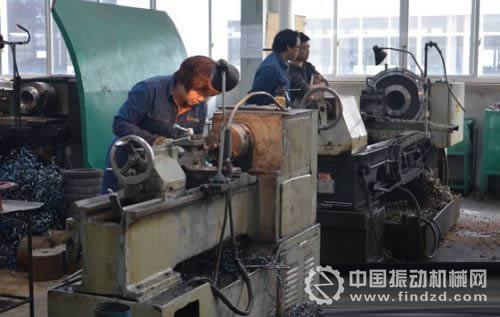图为工作人员在生产车间现场加工矿山机械产品零件。