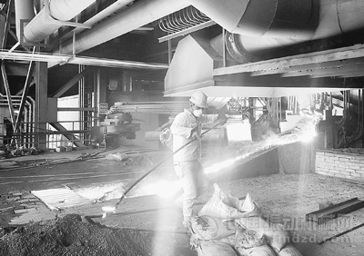 电炉出渣口，一位印尼工人熟练地取出镍渣样本。