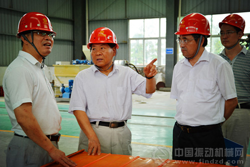 图为中国有色金属协会副会长康义(左二)与鑫鹰公司总经理洪镇波进行现场技术交流