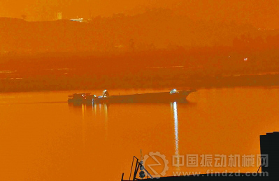 吸砂船夜间在江中采砂,工人有作业时,就打手电照明。