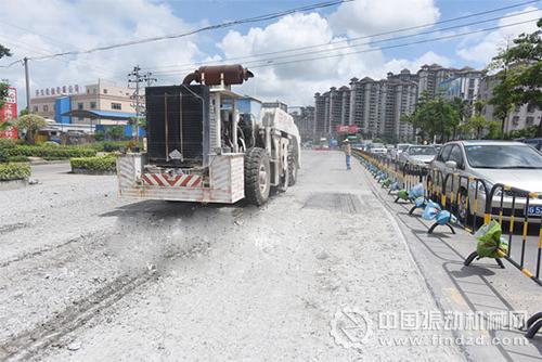 一辆大型共振破碎机行驶过后,路面留下一行共振破碎的水泥碎石