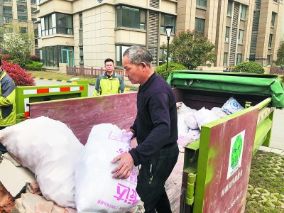 装修工人将建筑垃圾装袋后放入小区集中分类处置箱内